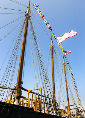 Three masts of the C.A. Thayer adorned with navel flags in San Francisco Maritime NHP