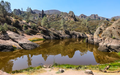 Surrounding rock formations reflected in the Bear Gulch Reservoir in Pinnacles National Park