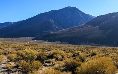 Early evening sunlight stretches across the foothills along the Eastern Sierras