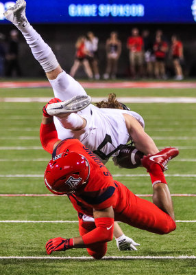 Arizona FS Scottie Young upends Oregon WR Brenden Schooler after a catch