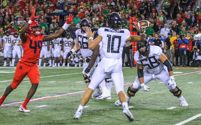 Wildcats DE Jalen Harris looks to disrupt an Oregon QB Herbert pass