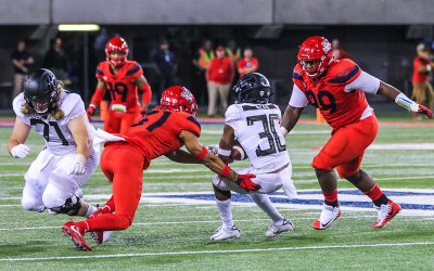 Cats S Tristan Cooper and DT Dereck Boles stop Ducks WR Jaylon Redd after a catch