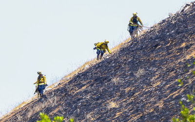 Firefighters check the steep hills for hot spots at the site of the Black Mountain West Marin fire