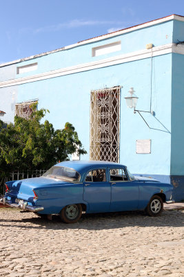 Blue car in front of blue building