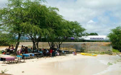 2009 - military families at the beach next to the taxiway with Hawaiian Airlines Boeing 717 taxiing out to the reef runway
