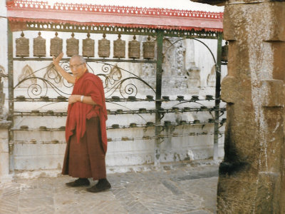 Buddist priest turns prayer wheels