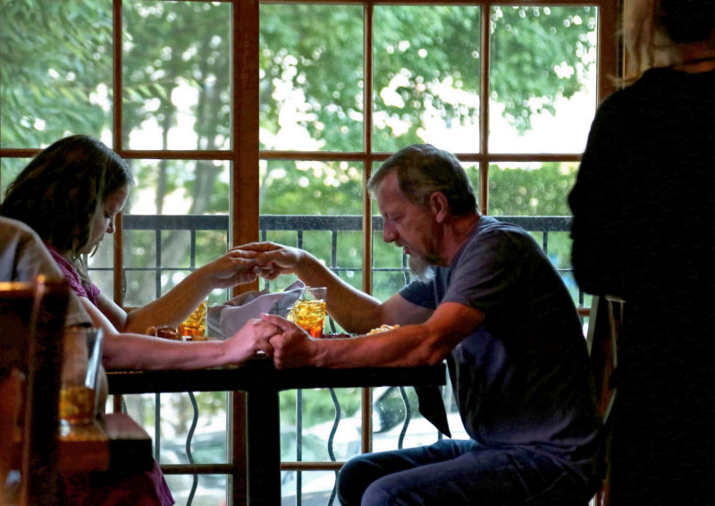 COUPLE PRAYING BEFORE SUPPER