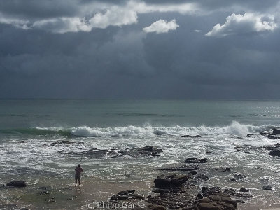 A lone fisherman under stormy skies