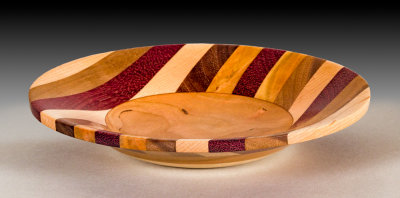 Shallow bowl made with numerous laminated woods.
