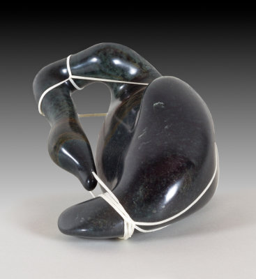 Soapstone carving of bird entangled in fishing line.