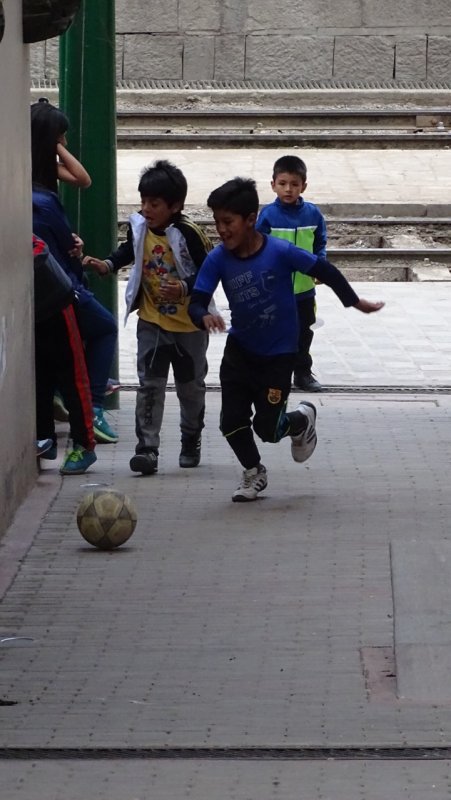 Kids playing football on a small street in Aguas Calientes