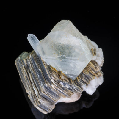 22 mm white fluorite octahedron on a 3 cm book of muscovite. Chumar Bakhoor, Gilgit District, Northern Areas, Pakistan.