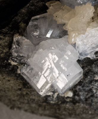 Phillipsite with Marburg cross twin, 1 cm, with a trigonal sheaf of yellow calcites on 35 mm basaltic matrix. Alter Stein 