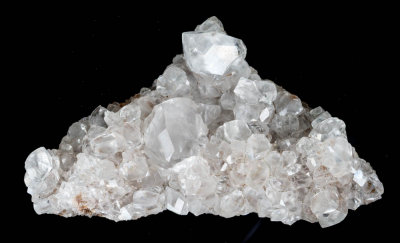 Calcite, lustrous transparent crystals to 20 mm in 75 mm group. Frizington, West Cumbria, England. The main crystal is twinned.