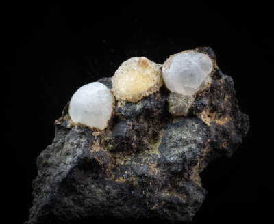 Two 5 mm thomsonite balls and a 7 mm yellow calcite ball grown around a scalenohedron on 26 mm matrix. Alter Stein Quarry