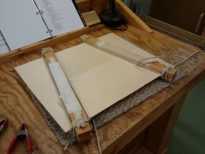 Glueing top and bottom pieces together with wood and rope clamps.