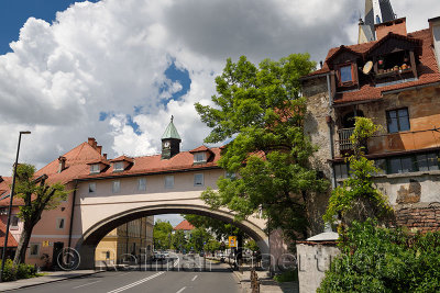 Building arch with rooms and clock tower over four lane Karlovska road with St. James Catholic church belfry Ljubljana Slovenia