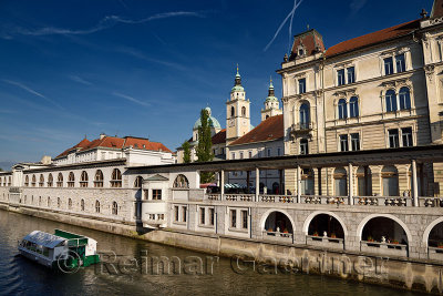 Tour boat on the Ljubljanica river canal at Kresija Building St Nicholas Cathedral at Pogacar Square and Central Market Ljubljan