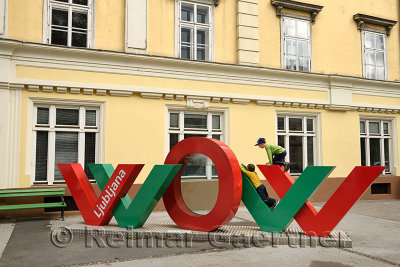 Two boys climbing on red and green interactive WOW art installation at the Slovenian Tourist Information Centre of Ljubljana Slo