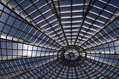 Abstract spiderweb view of a central tower skylight at the World War I memorial ossuary in Oslavia Italy with a blue sky