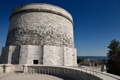 War memorial for the fallen in World War I and tomb of 57,741 soldiers in white stone at Oslavia Italy against a blue sky
