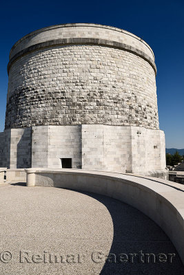 Monument to the fallen in World War I and tomb of 57,741 soldiers in white stone at Oslavia Italy against a blue sky