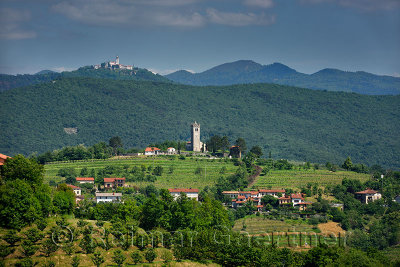 View of Church of the Holy Cross in Kojsko and Sveta Goro Holy Mountain with Basilica of the Assumption of Mary from Smartno Brd