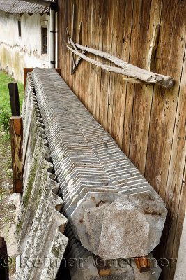 Stacked stone cement slate roof tiles next to wood barn in rural village of Selo pri Bledu near Bled Slovenia