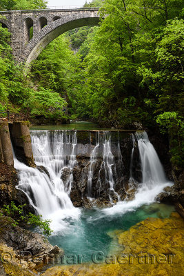 Single arch stone bridge for Bohinj railway over the Radovna river valley at Vintgar Gorge with Waterfalls at Dam sluice gate Sl