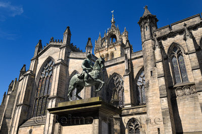 Bronze sculpture of Charles II on horseback at south side of St Giles' Cathedral with crown steeple Edinburgh Scotland United Ki