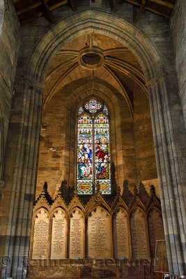 Stained glass window of Jesus Christ teaching at the back of the medieval Church of the Holy Rude with memorials to benefactors 