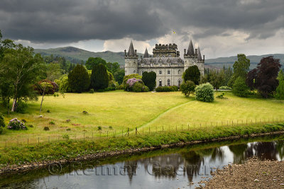 Inveraray Castle reflected in the River Aray at Loch Fyne with dark clouds and golden grass in the Scottish Highlands Scotland U