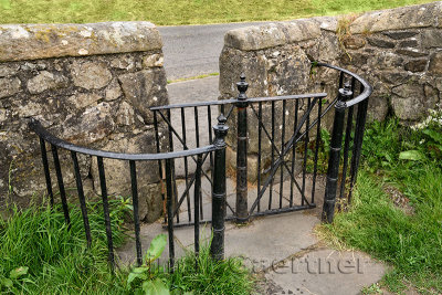 Kissing Gate with stone wall at pastureland under Stirling Castle that lets people but not sheep pass through 