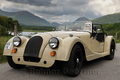 Woman in a hand made wood shell Morgan roadster car in the Scottish Highlands near Kilchurn Castel at Loch Awe Scotland UK