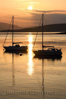 Full sun reflecting on the water of Ardmucknish Bay at North Connel and Oban Airport with sailboats in silhouette