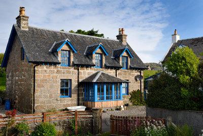 Stone house with blue trim and flower garden on main street of Baile Mor village on Isle of Iona Inner Hebrides Scotland UK