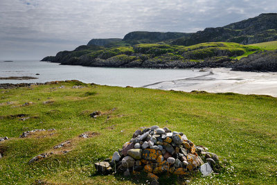 Cairn pile of stones on sea cliff at Sandeels Bay beach on Isle of Iona Inner Hebrides Scotland UK