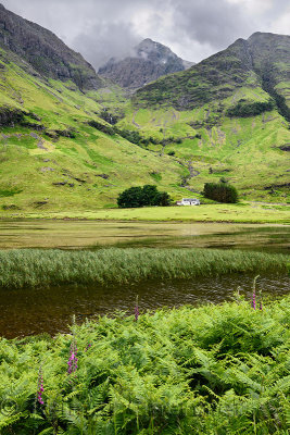 Achnambeithach cottage on Loch Achtriochtan under Aonach Dubh waterfall and Bidean nam Bian mountains Glen Coe valley Scotland U