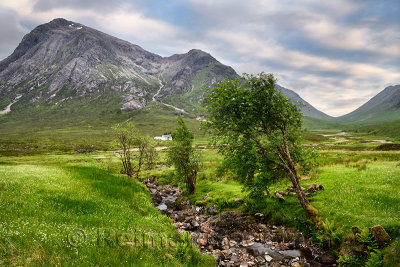 Stream to River Coupall valley with white cottage at foot of Stob Dhearg peak of Buachaille Etive Mor mountains Glen Coe Scotlan
