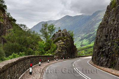 Curving Highway A82 through rock cliffs with Aonach Eagach Ridge mountains north of Glen Coe valley Scottish Highlands Scotland 