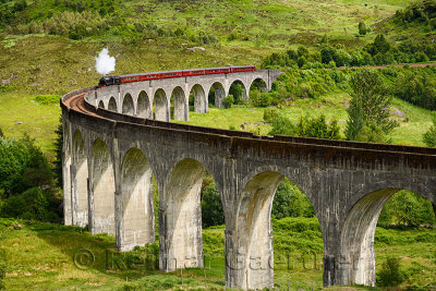 Red heritage Jacobite coal fired Steam Train used in Harry Potter films at Glenfinnan viaduct in the Scottish Highlands Scotland