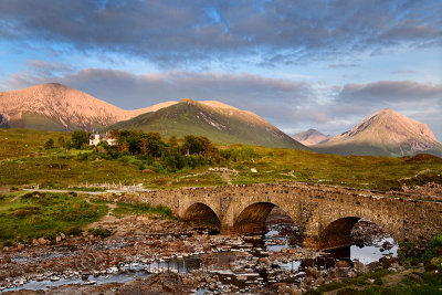 Sligachan Old stone Bridge over River Sligachan with Beinn Dearg Mhor and Marsco peak of Red Cuillin mountains at sunset Isle of