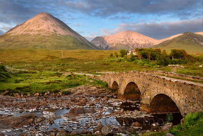 Sligachan Old stone Bridge over River Sligachan with Glamaig and Beinn Dearg Mhor peaks of Red Cuillin mountains at sunset Isle 
