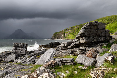 Cliffs and shore north of Elgol Port na Cullaidh with Red Cuillin Mountains under dark clouds on Loch Scavaig Isle of Skye Scotl