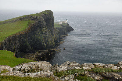 Neist Point Lighthouse in high winds and stinging rain with sheer basalt cliffs to Oisgill Bay Atlantic Ocean Isle of Skye Scotl