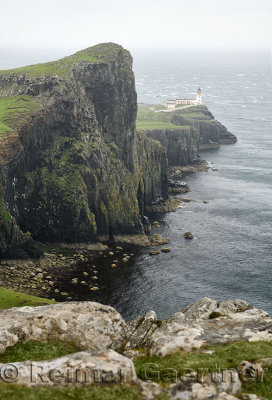 Neist Point Lighthouse in high winds and rain with sheer basalt cliffs to Oisgill Bay Atlantic Ocean Isle of Skye Scotland UK