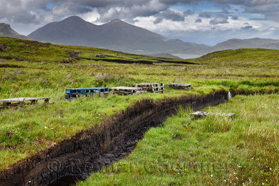 Trenches cut into deep Peat of wetland moors near Drinan on Isle of Skye Scotland with Loch Slap and Beinn Dearg Mhor and Beinn 