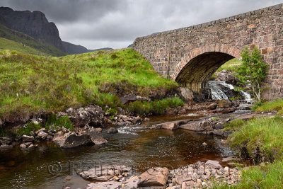 Red stone bridge over Russel Burn river of Bealach na Ba road mountain pass on Applecross Peninsula Scottish Highlands Scotland 