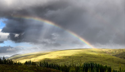 Double rainbow and dark clouds on An Liathanach mountain at Loch a Chroisg near Badavanich Scottish Highlands Scotland UK