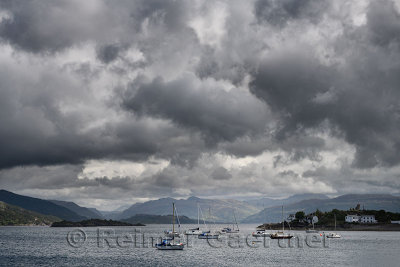 Sailboats on Kyle Akin straight to Loch Alsh at Kyleakin Isle of Skye with Caisteal Maol and dark clouds Scottish Highlands Scot